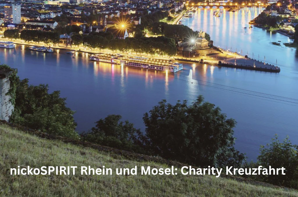 Ein beleuchtetes Flusskreuzfahrtschiff bei Nacht auf einem Fluss nahe einer beleuchteten Uferpromenade und einer Landzunge. Im Vordergrund steht der Text „nickoSPIRIT Rhein und Mosel: Charity Kreuzfahrt“.
