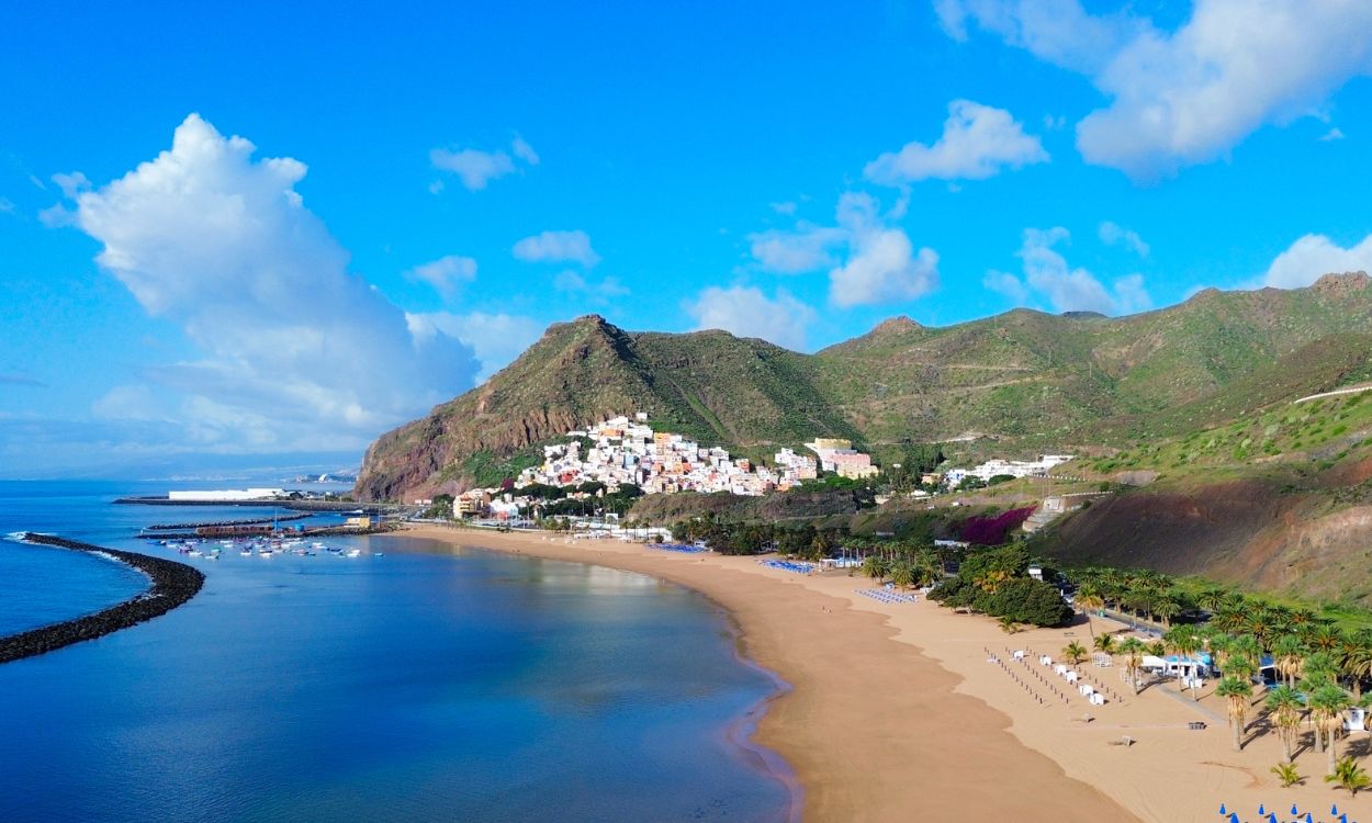 Luftaufnahme des goldenen Sandstrands Playa de Las Teresitas auf Teneriffa mit Bergen im Hintergrund und buntem Küstenort. Luftaufnahme des goldenen Sandstrands Playa de Las Teresitas auf Teneriffa mit Bergen im Hintergrund und buntem Küstenort.